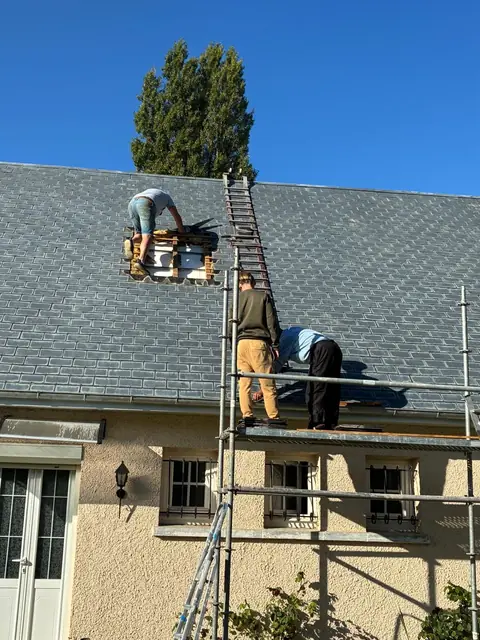 Couvreurs de Styven Couverture sur une toiture en ardoise, depuis un échafaudage